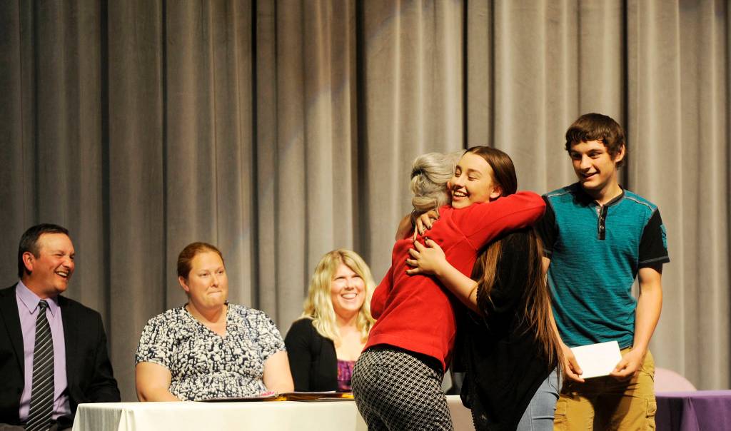 Mary Jane Duncan gives Bob Duncan Memorial Scholarships and hugs to SHS graduating seniors Chloe Ann Erickson and Levi Foy; from left, Sequim High School principal Shawn Langston and counselors Erin Fox and Melee Vandervelde look on. Sequim Gazette photo by Michael Dashiell