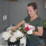 Kamama Flowers owner April Lemly gathers flowers together in her flower bar at Peninsula Taproom. For Lemly, flowers are more than just display pieces, flowers are an extension of your table, she says. Sequim Gazette photo by Erin Hawkins
