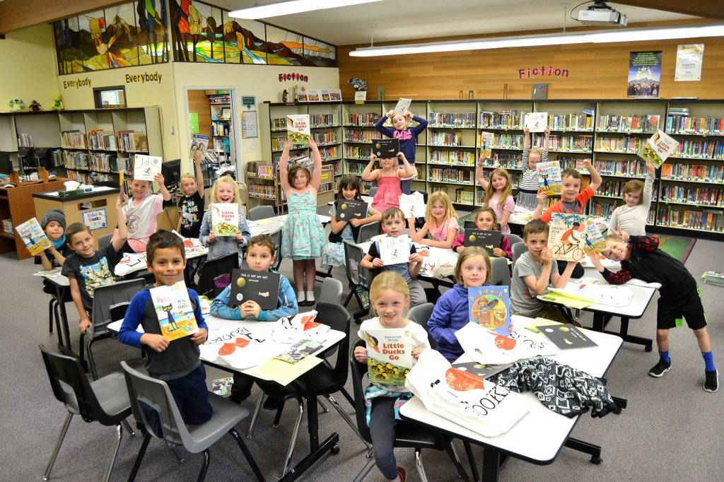 Bettina Hoesels first grade students hold up their favorite book they received through the Six Books for Summer program last week. In its second year at Helen Haller Elementary, school officials said the program helped maintain or increase reading levels in four of five participating grade levels. Sequim Gazette photos by Matthew Nash