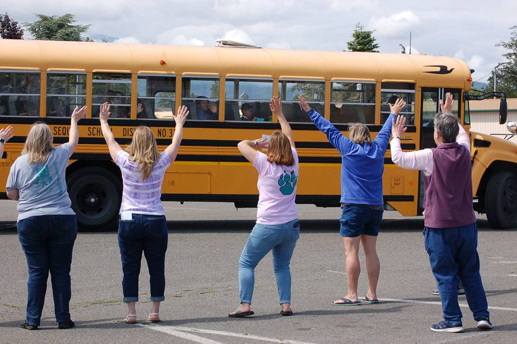 Sequim School District teachers and staff wave to students as they head home for summer on the last day of school for the 2017-2018 school year. Sequim Gazette photo by Erin Hawkins