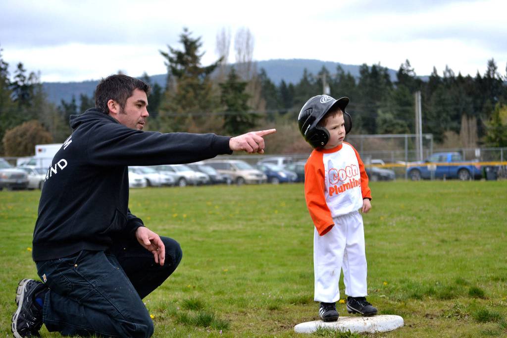 Len Horst serves as third base coach for his son Parker during a T-ball game earlier this season. Coon Plumbing was one of six T-ball teams with Sequim Little League.