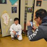 Rockey Del snaps a picture of his son Yeshua Del, 8, at the Helen Haller Elementary Art Show on June 4. Yeshua, in Rachel Odens art class, said he enjoyed following Salvador Dalis style because enjoys math and was able to use Roman numerals. Sequim Gazette photo by Matthew Nash