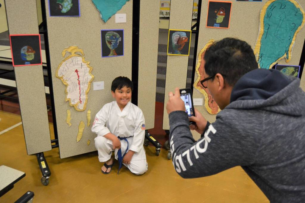 Rockey Del snaps a picture of his son Yeshua Del, 8, at the Helen Haller Elementary Art Show on June 4. Yeshua, in Rachel Odens art class, said he enjoyed following Salvador Dalis style because enjoys math and was able to use Roman numerals. Sequim Gazette photo by Matthew Nash