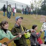 Ashley Kramer and Joe Bridge of Sequim play music at the Families Belong Together rally near the U.S. Border Patrol building in Port Angeles on Saturday. Similar rallies were taking place across the country to protest federal immigration policies. (Rob Ollikainen/Peninsula Daily News)