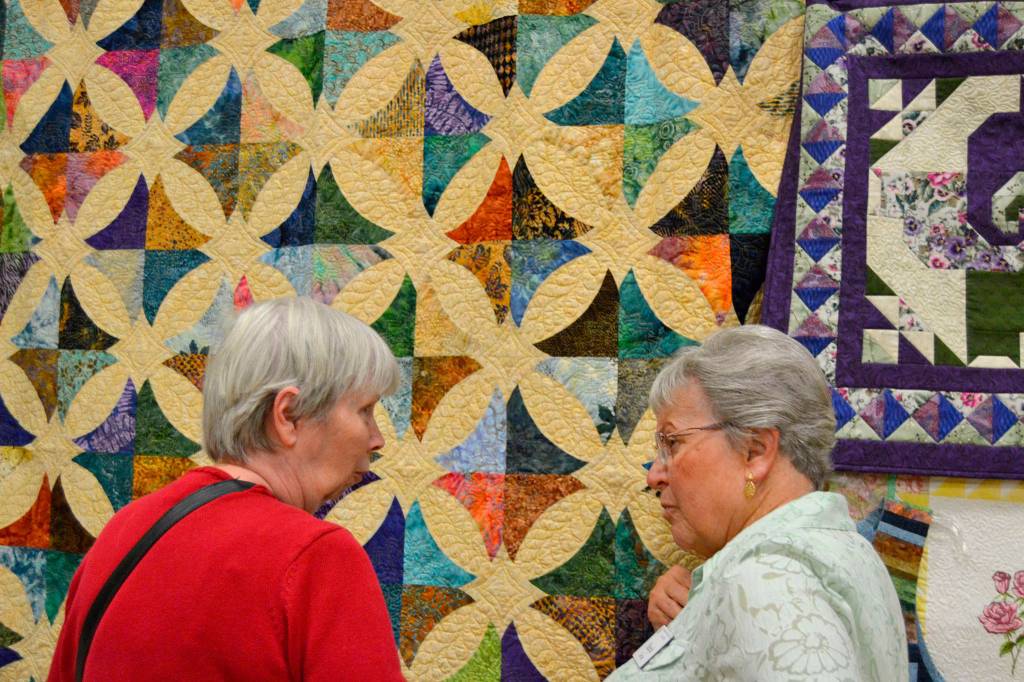 Last years featured artist Murph Gerber, left, talks about her technique with Trudie Holt of Bremerton at the Sunbonnet Sue Quilt Clubs annual show in 2017. This years show returns to the school July 20-22. Sequim Gazette file photo by Matthew Nash