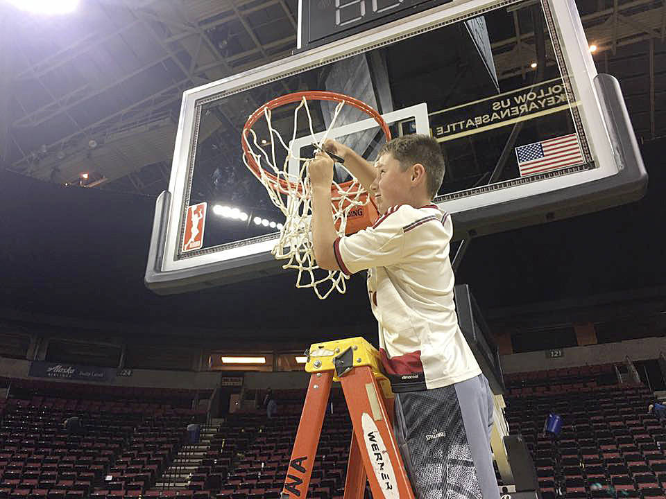 Kaiden Tosland cuts down a net after he and fellow Boys & Girls Club campers enjoyed a Seattle Storm basketball game last week. Submitted photo