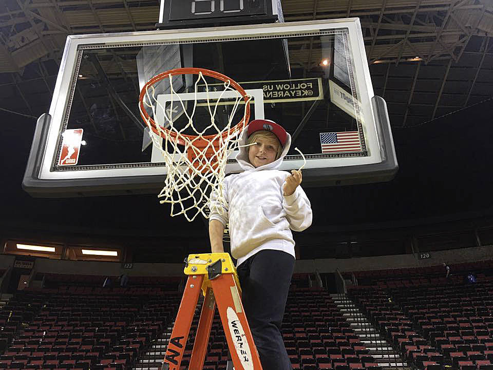 MacKenzie Worley cuts down a net after he and fellow Boys & Girls Club campers enjoyed a Seattle Storm basketball game last week. Submitted photo
