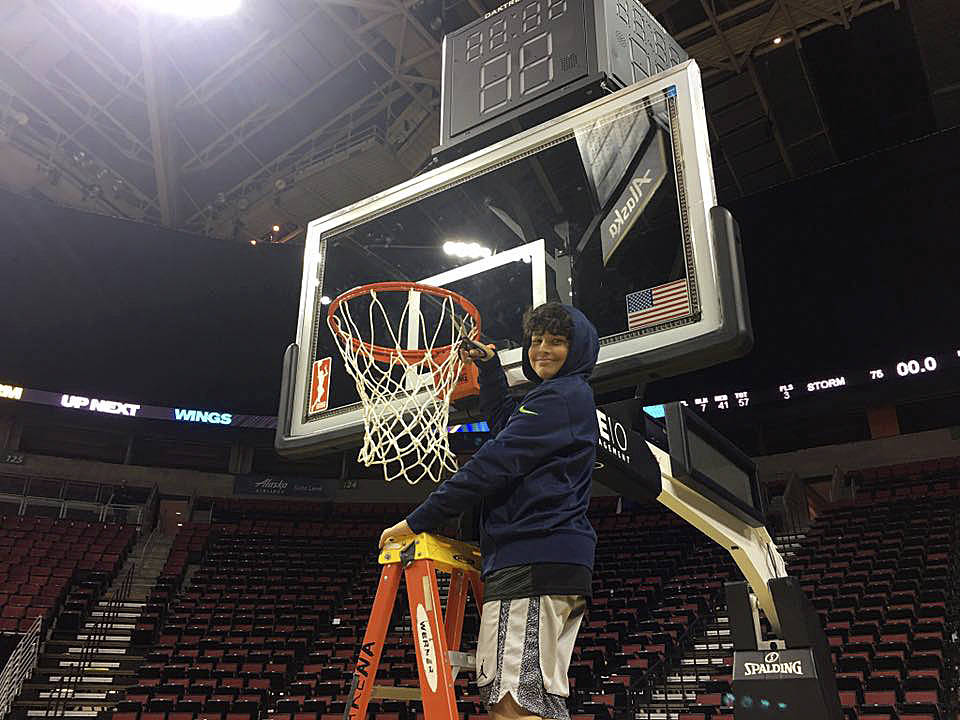 Saul Williams cuts down a net after he and fellow Boys & Girls Club campers enjoyed a Seattle Storm basketball game last week. Submitted photo