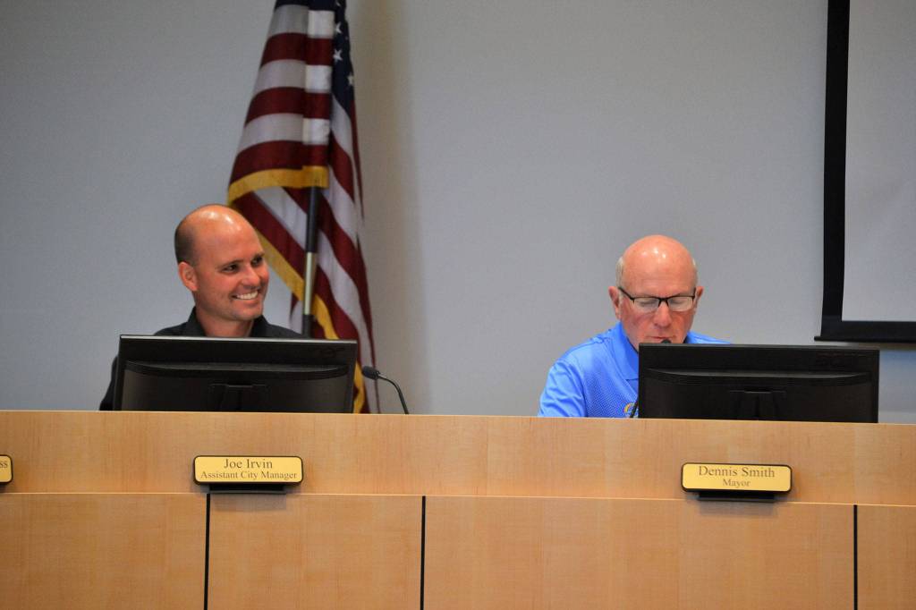 Joe Irvin, Sequim assistant city manager, smiles as Mayor Dennis Smith reads a resolution on July 23 recognizing Irvin for his service with the city. Irvins last day was July 24 before taking a job in California. Sequim Gazette photo by Matthew Nash