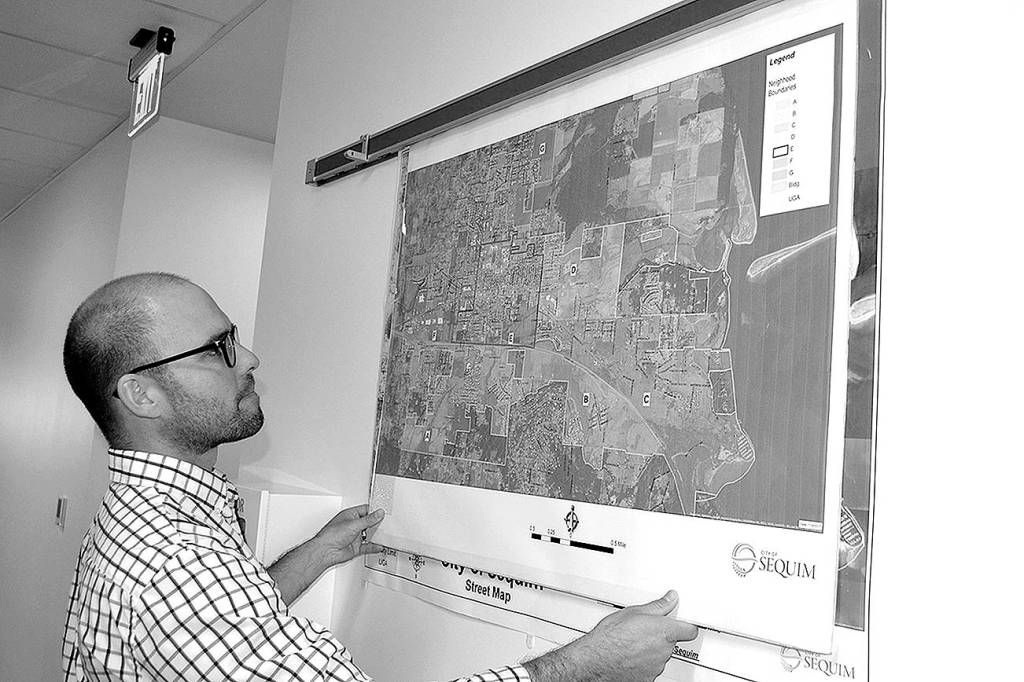 Sequim Assistant City Manager Joe Irvin holds maps of different regions in the City of Sequim in 2017 prior to a Neighborhood Visioning Meeting. Irvin plans to leave the city to work in Healdsburg, Calif. Sequim Gazette photo by Matthew Nash