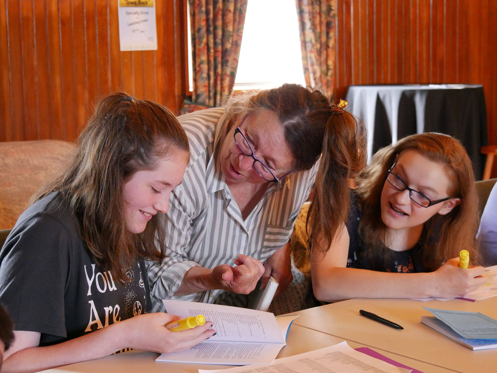 Bonne Smith, director of The Phantom Booth for Olympic Theatre Arts Childrens Troupe, speaks with Ava Fuller and Emily Loucks about their scripts for the upcoming play Aug. 31-Sept. 9. Photo by Pete Griffin