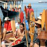 Keltsmaht Thomas of Ahousaht First Nations on Vancouver Island, standing at rear, asks for permission to come ashore at Hollywood Beach in Port Angeles on July 20, as a canoe belonging to Klahoose First Nation approaches behind him. Photo by Keith Thorpe/Peninsula Daily News