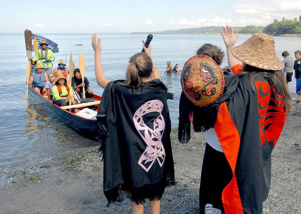 A canoe representing Sechelt First Nation of British Columbia is greeted by Lower Elwha Clallam tribal members, from left, Malena Marquez, 11, Emma Marquez, 1, and Wendy Sampson. Photo by Keith Thorpe/Peninsula Daily News