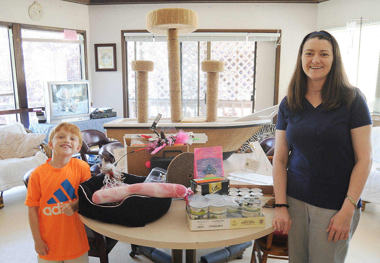 Tracy and Preston Coyle of Snohomish display some of the essentials their sponsorship funds help supply at Safe Haven, Peninsula Friends of Animals facility located between Sequim and Port Angeles. Sequim Gazette photo by Michael Dashiell