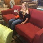 The Night at the Museum fundraiser event on Sunday, Aug. 12, is raising monies for the Robby Streett Legacy Fund to purchase new furniture for the Sequim High School Library, in honor of Robby Streett. Annie Armstrong, one of the organizers of the event sits on a couch at The Warehouse in Port Angeles in search of new furniture. Submitted photo