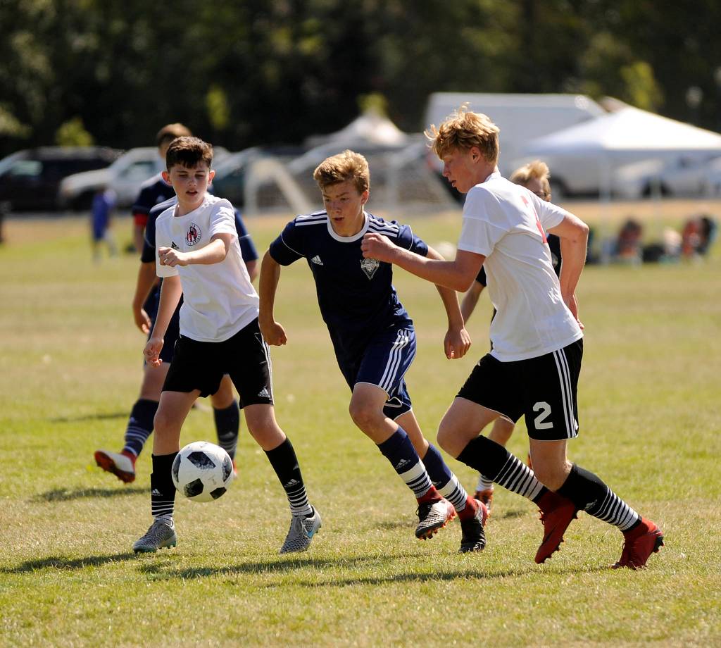 Ashton Smith of Storm King works his way through the Nortac Sparta B03 midfield in the BU16 championship game on Aug. 5. Nortac topped Storm King, 3-0. Sequim Gazette photo by Michael Dashiell