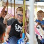 Port Angeles youngsters Carson Tillia, 4, and brother Evan, 3, take a ride on the carousel with mom Danielle at the Clallam County Fair carnival on Aug. 18.