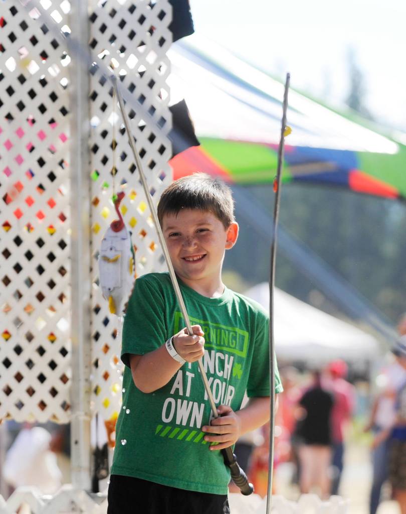 Kolton Mason, 7, of Port Angeles, goes fishing at the Clallam County Fair carnival on Aug. 18. Sequim Gazette photo by Michael Dashiell