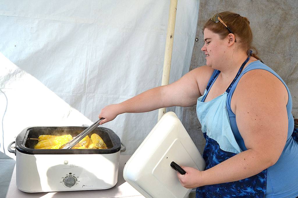 Lindsey Carlson, a majority member of the Sequim Rainbow Girls, readies some corn on the cob for the clubs annual booth at the fair. Carlson said shes been with Rainbow 14 years and she still loves the corn. It gets better every year, she said. Sequim Gazette photo by Matthew Nash