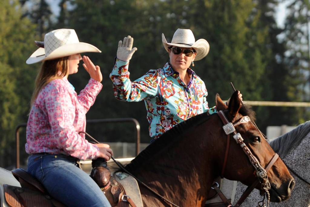 Mother-and-daughter combo Rashell (right) and Amelia Hermann of Port Angeles celebrate a quick time in the team roping competition at the Clallam County Fair Pro-West Rodeo on Aug. 18. Amelia is a Sequim High School freshman this fall.