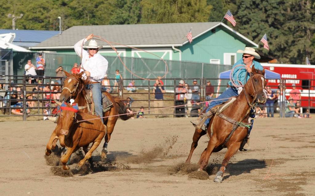Wyatt, left, and Rocky Billings look for a top time in the team roping competition at the Clallam County Fair Pro-West Rodeo on Aug. 18. Sequim Gazette photo by Michael Dashiell