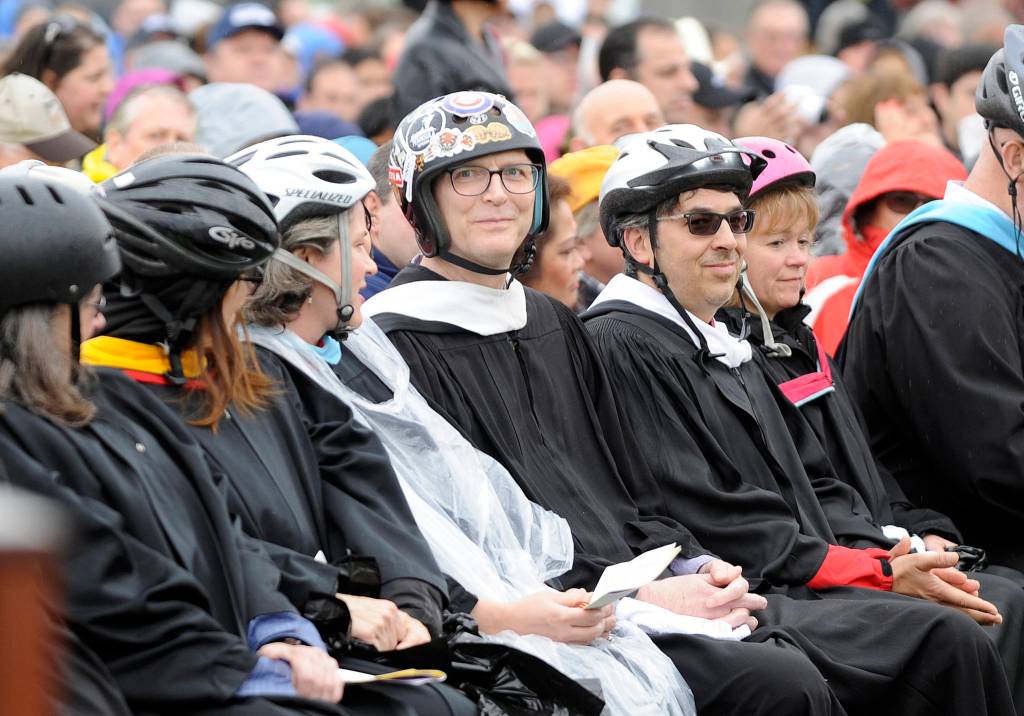 Jon Eekhoff, center, sits with his wife Cheryl, to his left, and fellow Sequim High School teachers during graduation on June 8. Teachers wore helmets in honor of him while he recovered from a cranectomy after he fell from his roof a few months prior. Sequim Gazette file photo by Michael Dashiell