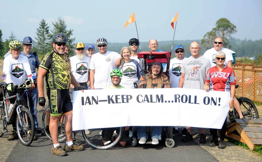 Ian Mackay, center, and his supporters stop to celebrate after crossing the Clallam-Jefferson County line on the Olympic Discovery Trail at Diamond Point Road on Friday, Aug. 24. Mackay had traveled on his wheelchair from Coeur dAlene, Idaho to highlight the need for wheelchair-accessible trails in Washington state. Sequim Gazette photo by Michael Dashiell