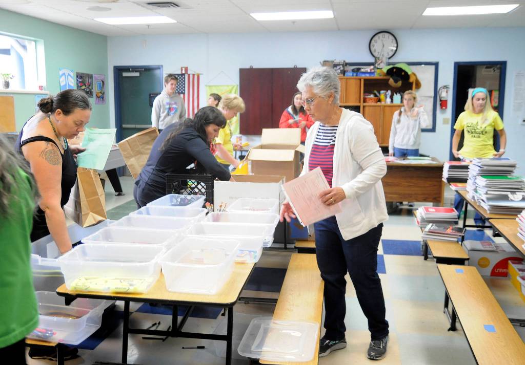 Volunteers at Saturdays Back to School Fair at the Sequim Boys & Girls Club organize school supply kits for local students.
