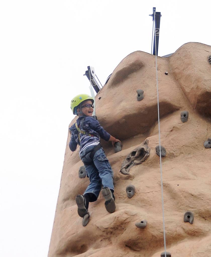 Tokgnar Davis, 6, is all smiles after reaching the top of a climbing wall at the Aug. 25 Back to School Fair in Sequim. He and twi brother Tungsten were both able to reach the top … twice. Sequim Gazette photo by Michael Dashiell