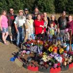 Brooke Bedingers family stands at her memorial on the side of US Highway 101 at the Morse Creek curve east of Port Angeles near the site where she died in a motorcycle wreck on June 21. From left, Pat Poage, Brookes uncle Woody Johnson, grandfather Gary Johnson, grandmother Debbie Johnson, uncle Josh Robbins, father Don Bedinger, mother Kim Bedinger with niece Ella Bedinger, brother Chase Bedinger, nephew Corbin Alves, grandmother Kathy Bedinger, brother Donald Bedinger and sister-in-law Katy Bedinger, stand together. Sequim Gazette photo by Erin Hawkins