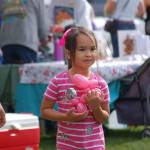 Isabella Greimes, 6, of Sequim, holds a balloon animal in the shape of a dog at the Sequim Dog Parks 11th-annual birthday celebration at Carrie Blake Park.