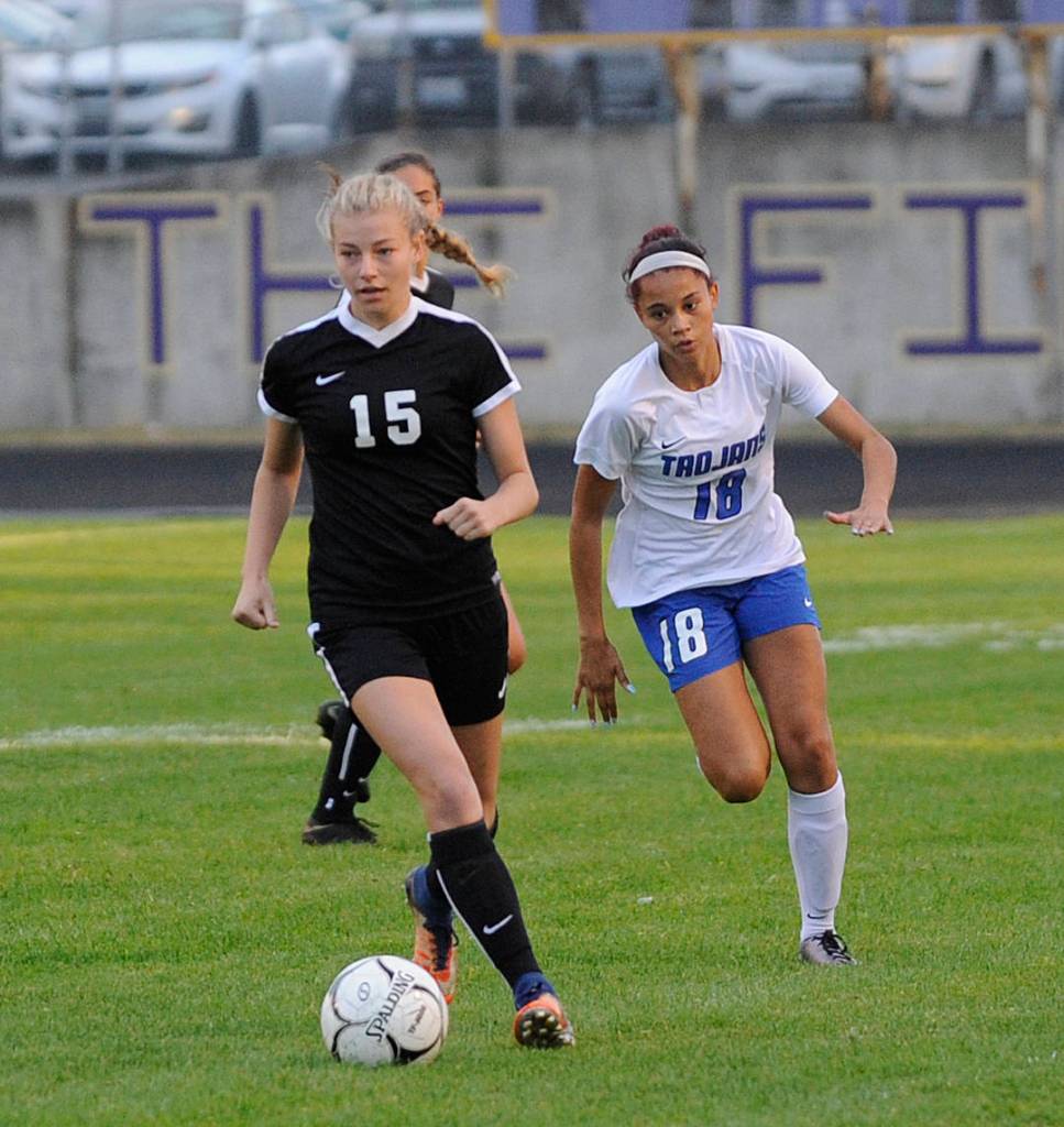 Sequims Autumn Hilliard, left, looks for an open teammate as Olympics Saoirse Brown pursues the play in the first half of a Sept. 13 Olympic League match-up. Sequim Gazette photo by Michael Dashiell