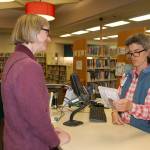 Sequim Library customer service specialist Mary Cote talks with Lindy MacLaine about a DVD at the Sequim Library on Sept. 21. Sequim Gazette photo by Erin Hawkins