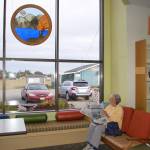 Joan McCready of Sequim sits near a large window and reads a local newspaper at the Sequim Library on Sept. 21. She regularly visits the library about once or twice a week. Sequim Gazette photo by Erin Hawkins