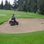 Thomas Matney, a maintenance worker for Sunland Golf & Country Club, rakes the sand on hole 18 on Sept. 25. The course now opens to the public after 2 p.m. weekdays and on Fridays after noon. Sequim Gazette photo by Matthew Nash