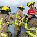 Marc Lawson, shift captain with Clallam County Fire District 3 (bottom right), helps fellow firefighters in a training exercise at the districts training center in Carlsborg. The fire district is asking voters to approve a levy lid lift in the Nov. 6 general election. Photo by Linda Barnfather