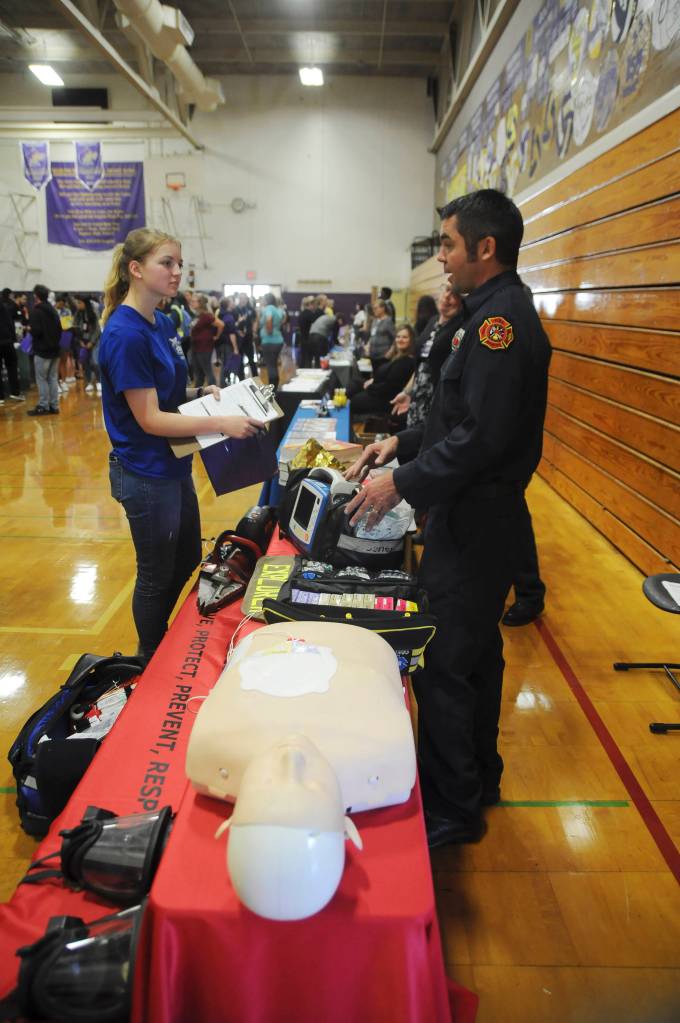Sequim High School student Madelyn Patterson talks with firefighter/paramedic Len Horst of Clallam County Fire District 3 at a college and career fair at SHS on Sept. 27. Sequim Gazette photo by Michael Dashiell