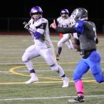 Sequim linebacker Johnnie Young, left, keeps a close eye on Olympic quarterback Ezekiel Gillick in the Wolves 28-9 win on Oct. 5. Sequim Gazette photo by Michael Dashiell