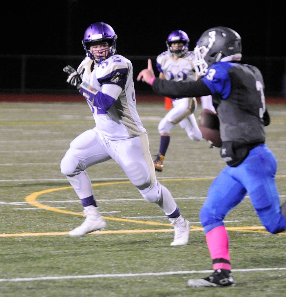 Sequim linebacker Johnnie Young, left, keeps a close eye on Olympic quarterback Ezekiel Gillick in the Wolves 28-9 win on Oct. 5. Sequim Gazette photo by Michael Dashiell