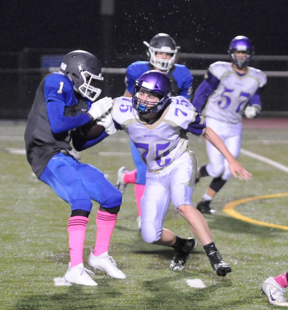 Sequim defensive lineman Austin Newton tries to wrap up Olympic running back Malcolm DeWalt in the first half of Sequims 28-9 win in Silverdale on Oct. 5. Sequim Gazette photo by Michael Dashiell