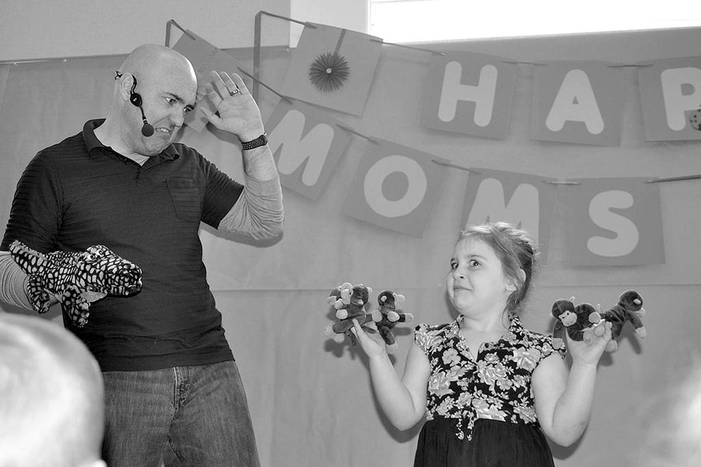 Mr. Silly Gilly, aka Glenn Gilliam, entertains a crowd (including 5-year-old Kyra Miller) with his own rendition of songs like Five Little Monkeys in April 2017. The photo took second place in the the 2018 WNPA Better Newspaper Contests Photography-Feature Portrait or Pictorial (black and white) division. Sequim Gazette photo by Matthew Nash