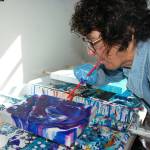 Artist Melanie Burns uses a straw to splatter paint around on one of her acrylic pouring pieces in her Sequim studio. When it comes to creating art, she says, I just have to. Sequm Gazette photo by Erin Hawkins