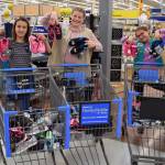 Sequim girl scouts, from left, Mia Kirner, Paige Krzyworz and Alexys Amaya go on a shoe shopping spree for foster children using donations from community members at the Sequim Walmart. Submitted photo