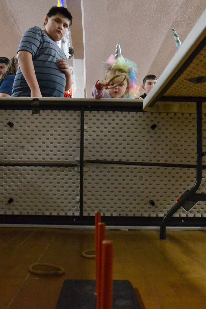 Scarlet Glavin, 3, of Sequim tries her hand at the ring toss as Kody Nash, 13, looks on at the Sequim Prairie Granges Country Fair. Sequim Gazette photo by Matthew Nash