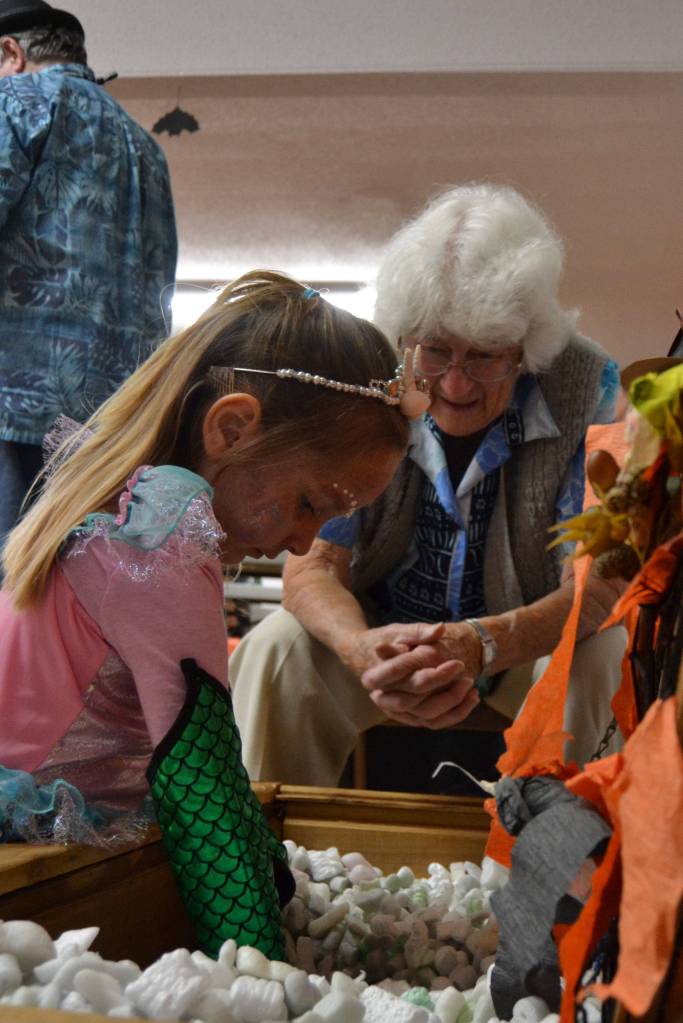 Aubrey Riley, 5, of Sequim searches for treasure as Helen Bucher watches at the Sequim Prairie Granges Country Fair. Sequim Gazette photo by Matthew Nash