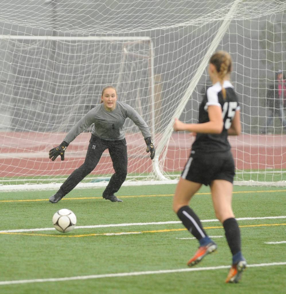 As teammate Autumn Hilliard (15) looks on, Sequim keeper Olivia Hare makes a stop in the first half of the Wolves 1-0 win against North Kitsap on Nov. 3. Sequim Gazette photo by Michael Dashiell