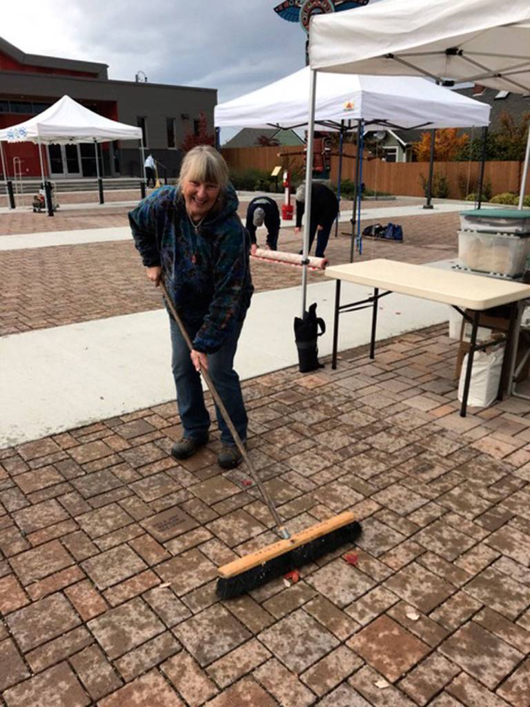 Suzy Killins of Rockin Rocks helps clean up the Sequim Civic Center Plaza on Oct. 27 after another successful season for the Sequim Farmers Market. Photo courtesy of Elli Rose