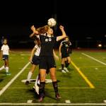 Sequims Hope Glasser (20) heads the ball over an Ellensburg defender in the first half. Sequim Gazette photo by Michael Dashiell