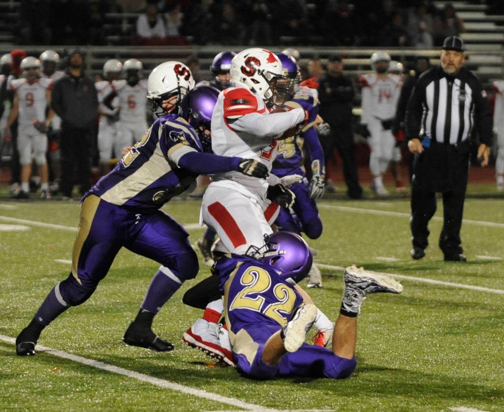 Sequims Johnnie Young, left, and Walker Ward (22) wrap up Steilacoom running back Jaymason Willingham. Sequim Gazette photo by Michael Dashiell