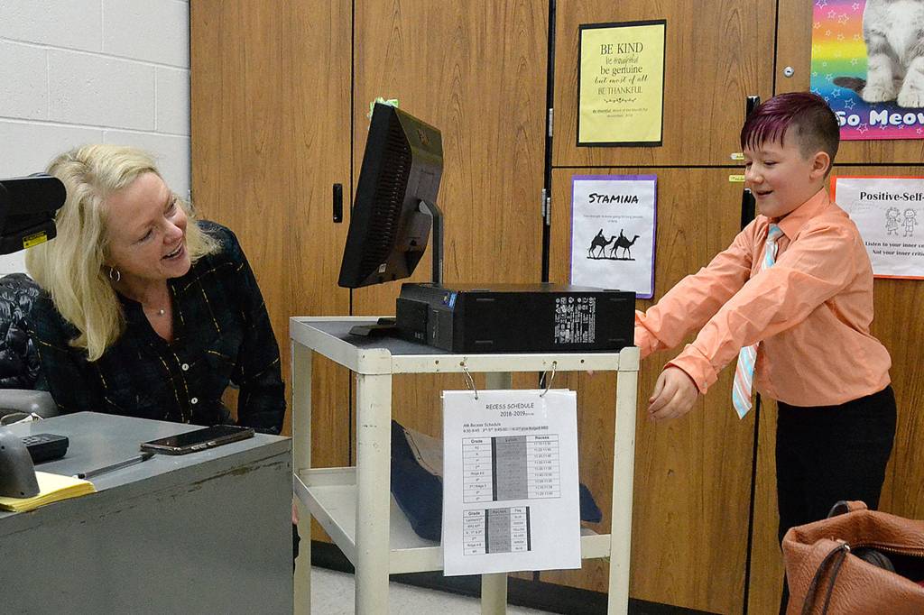 Aiden Johnson presents his third grade teacher Lambert Grimes a computer he refurbished for her to thank her for hosting and supporting Roosevelt Elementarys Computer Club. Sequim Gazette photo by Matthew Nash